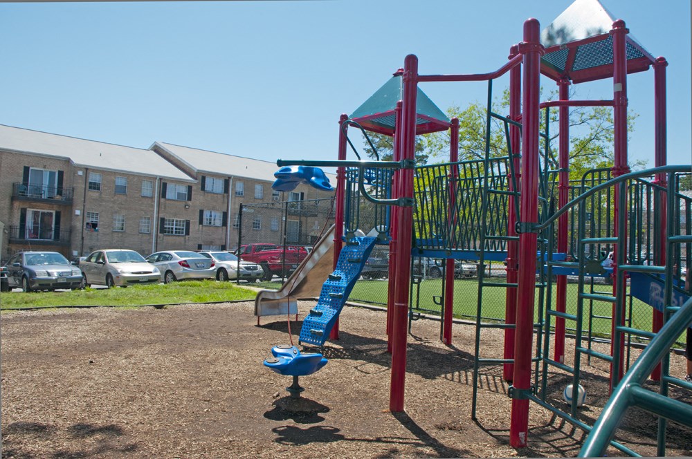 a playground with a slide in front of an apartment building