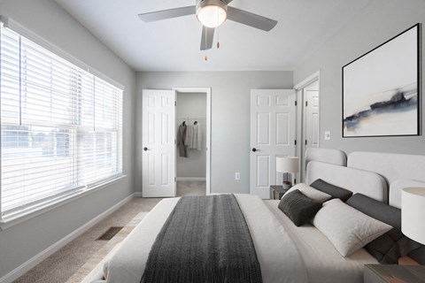 A bedroom with a large bed and a ceiling fan.