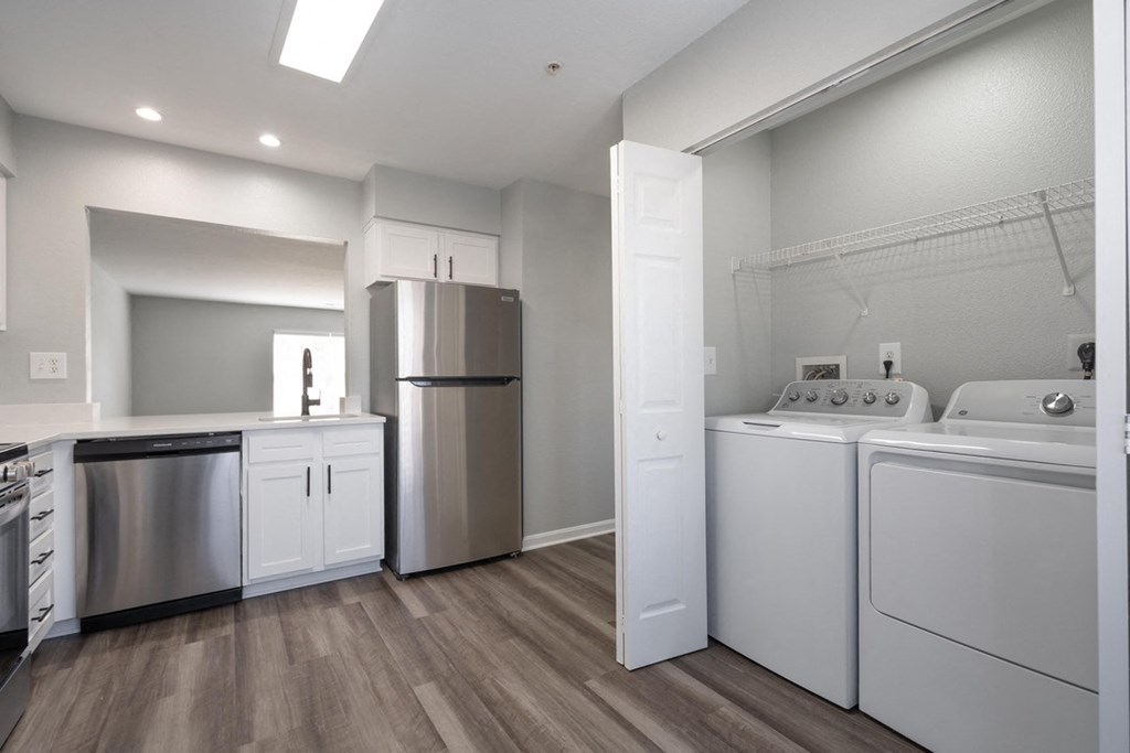 A modern kitchen with stainless steel appliances and white cabinets.