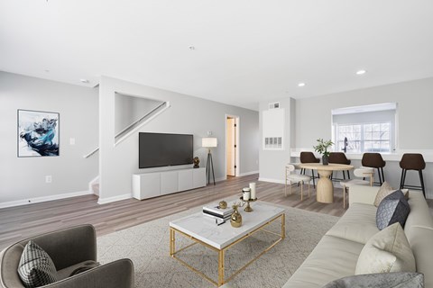 A living room with a grey couch, a coffee table, and a painting on the wall.