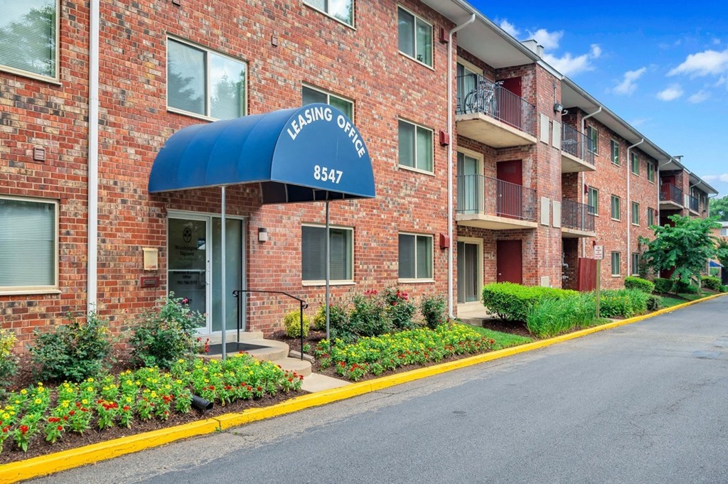 a brick building with a blue awning and a street in front of it