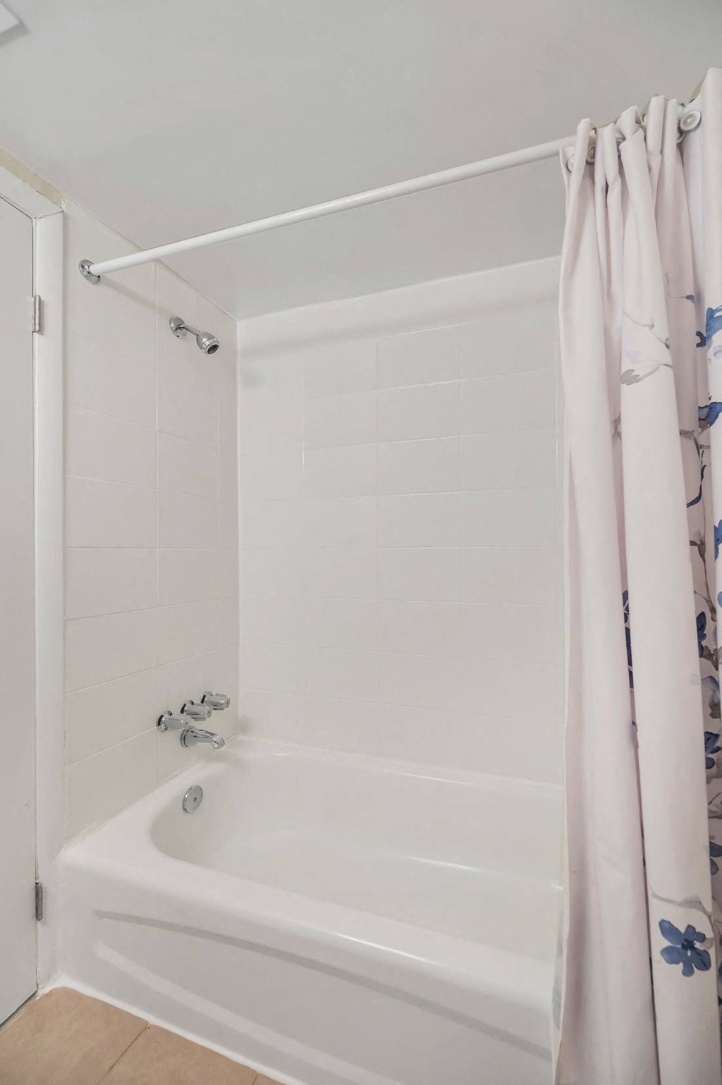 a white tub sitting next to a white shower curtain