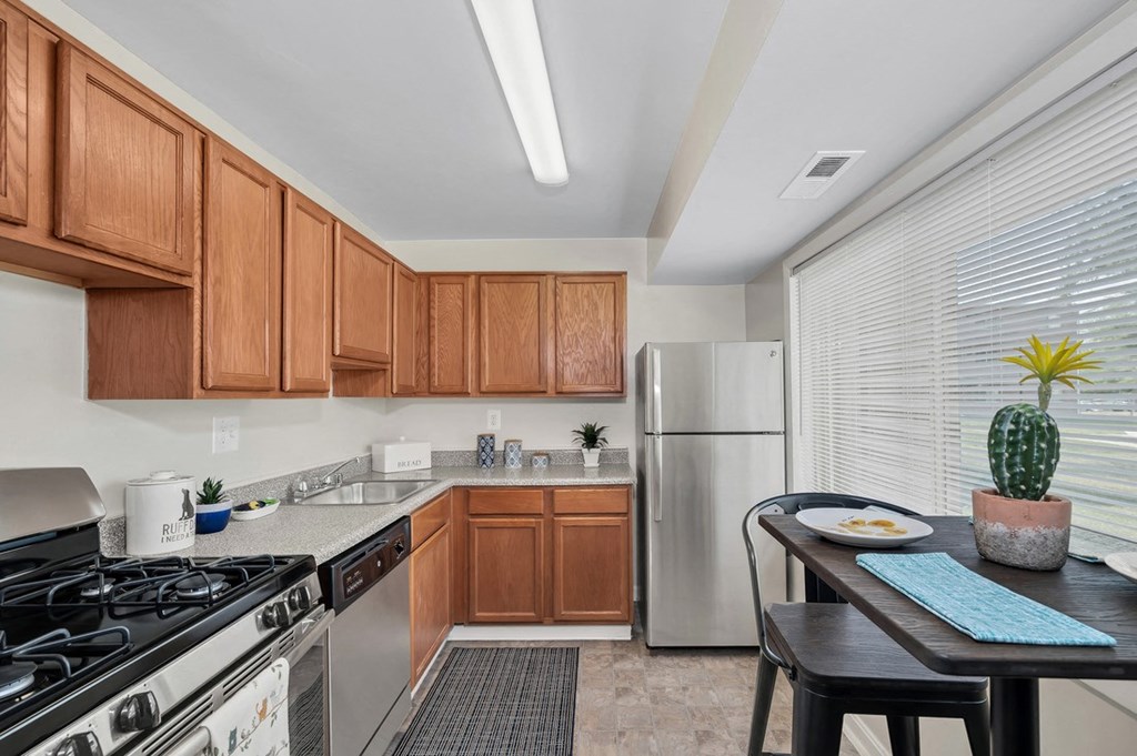 a kitchen with wood cabinets and stainless steel appliances