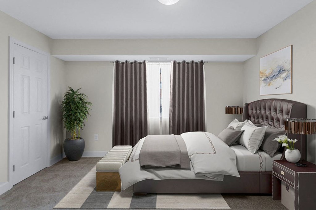 A bedroom with a large bed and a potted plant.