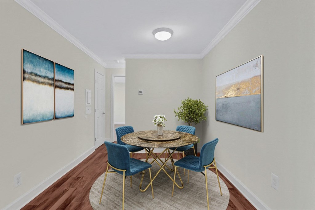 A dining room with a round table and blue chairs.