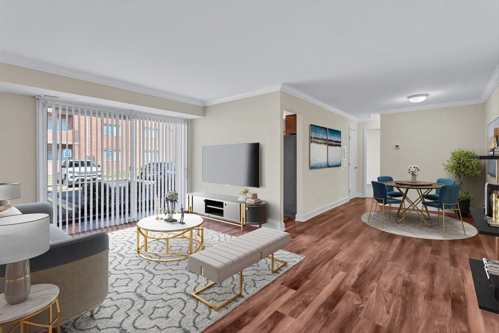 A living room with a television, a sofa, a chair, a table, and a potted plant.