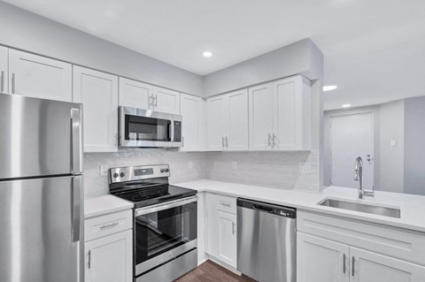 a kitchen with white cabinets and stainless steel appliances