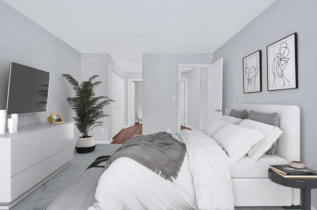 A sophisticated bedroom displaying a pristine white bed and a contemporary television.