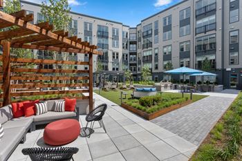 an outdoor patio with a fire pit and seating area at the shoreline