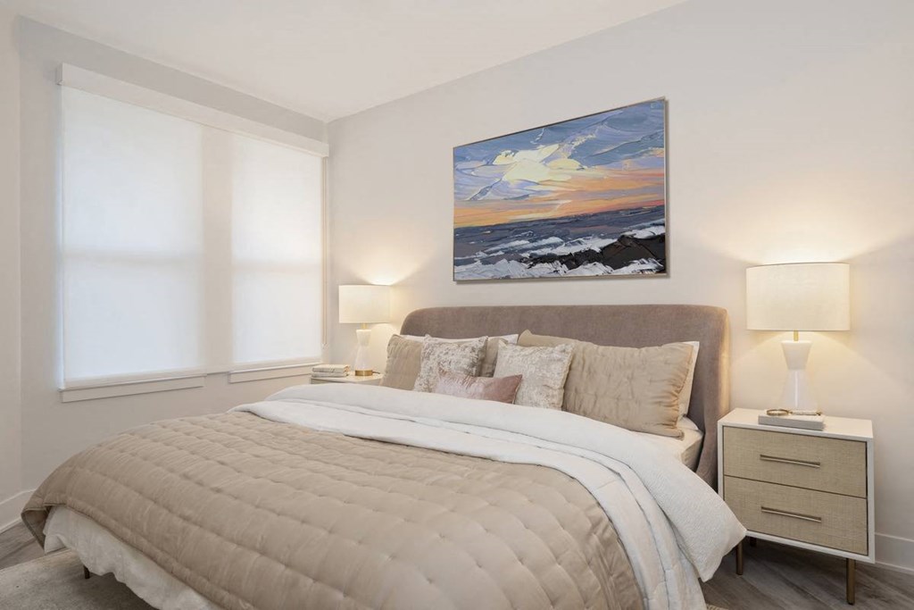 a bedroom with a bed and a painting on the wall