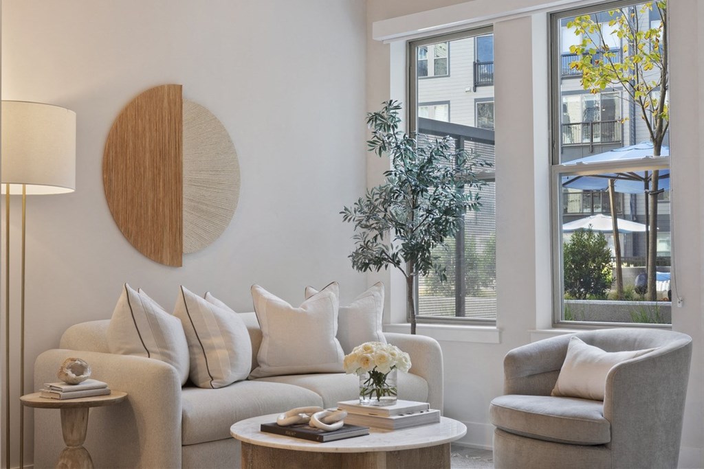 a living room with a couch and chairs and a large window