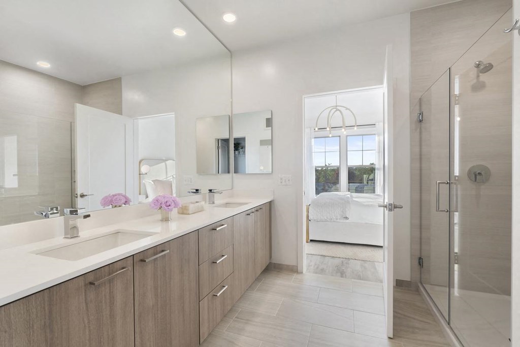 a bathroom with two sinks and a shower and a bed