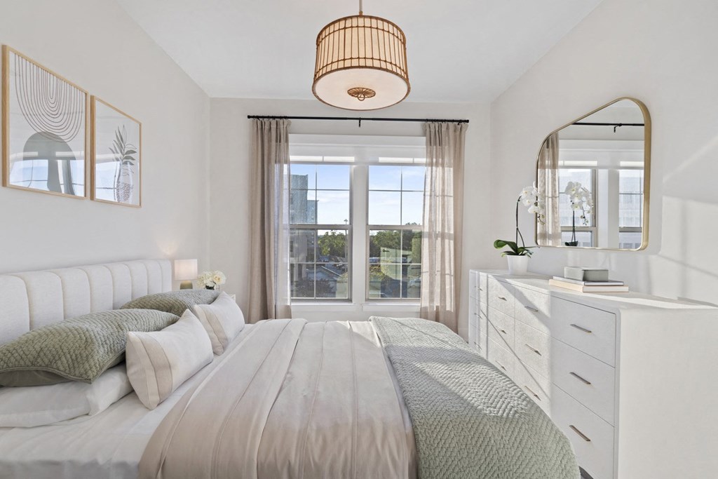 a white bedroom with a bed and a window