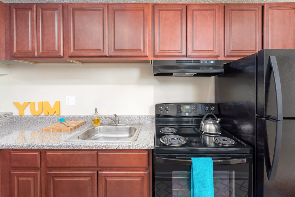 a kitchen with black appliances and wooden cabinets