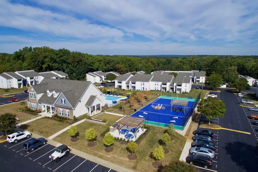 an aerial view of a neighborhood with a tennis court and parking lot