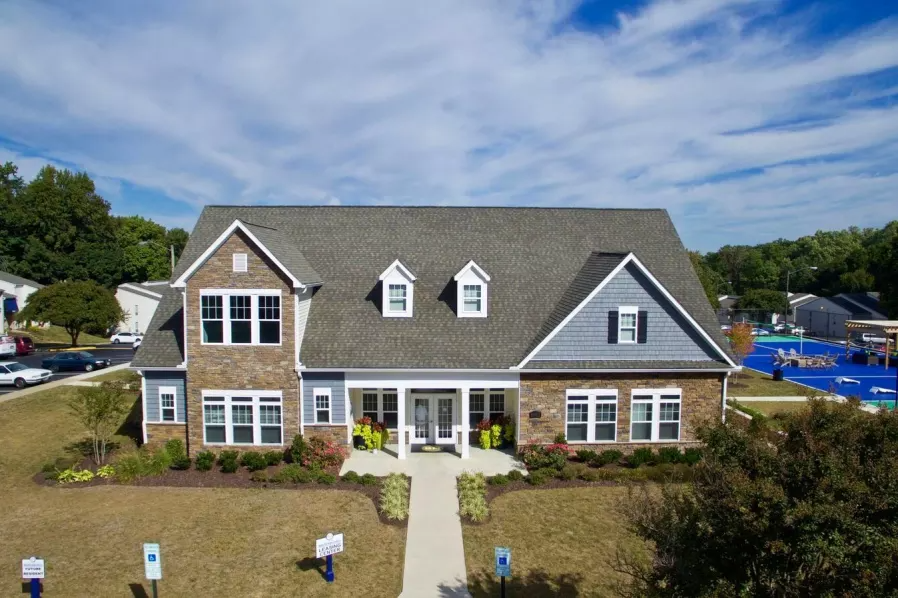 a large brick house with a gray roof and white windows