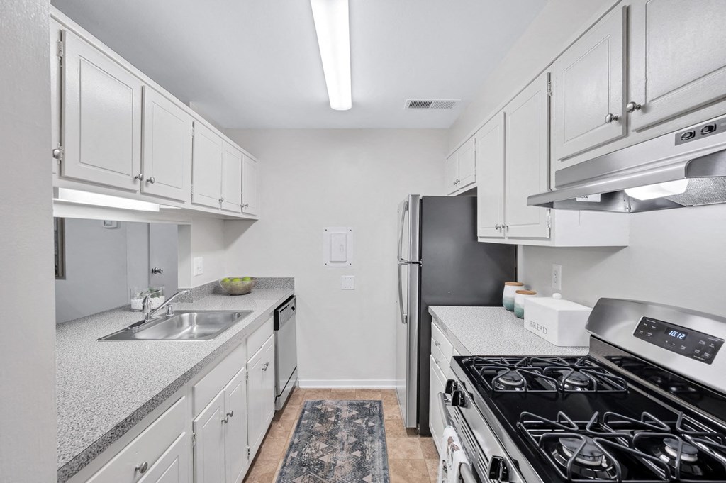 a kitchen with white cabinets and a black stove top oven