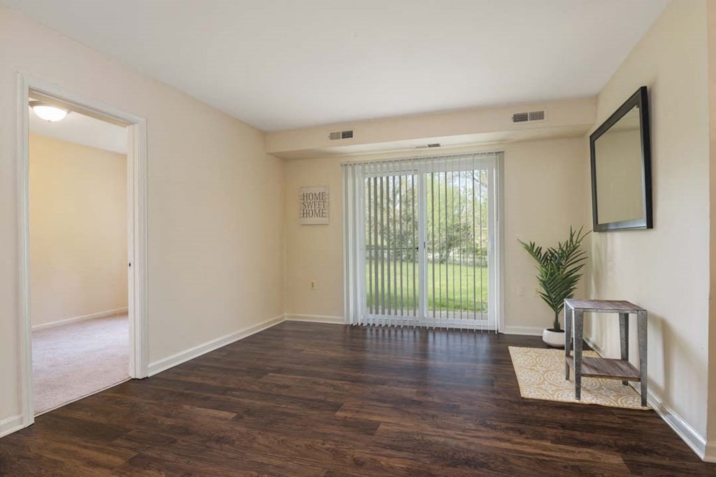 an empty living room with a sliding glass door and a window
