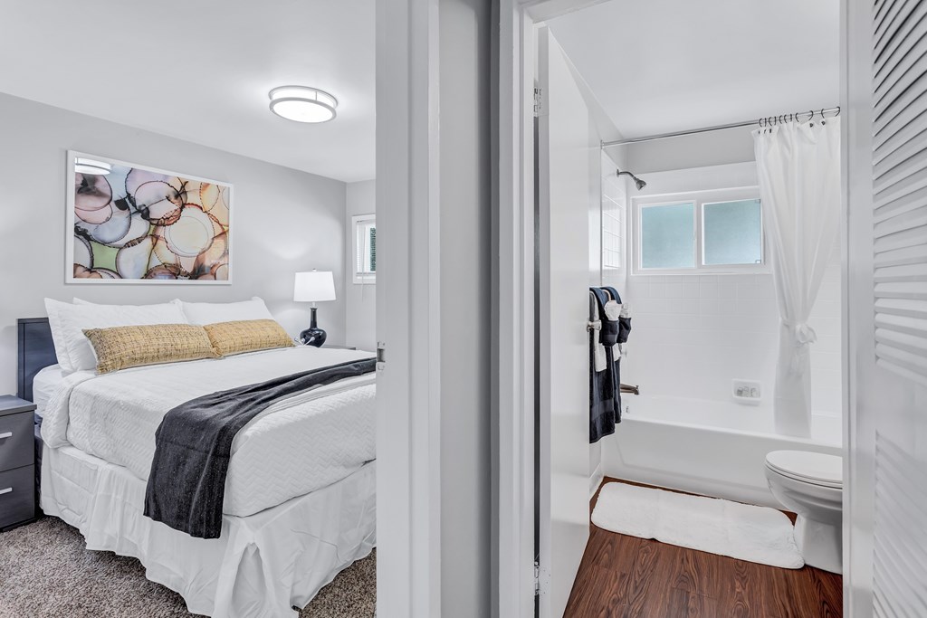 a bedroom with a bed and a bathroom with a shower
