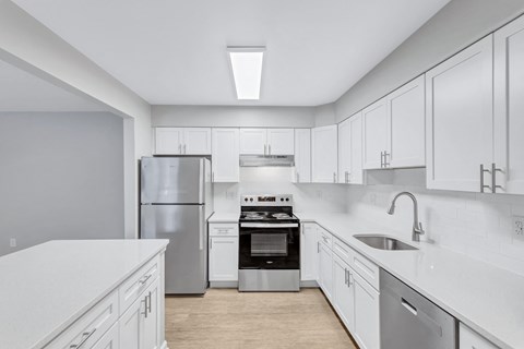 a large white kitchen with white cabinets and stainless steel appliances