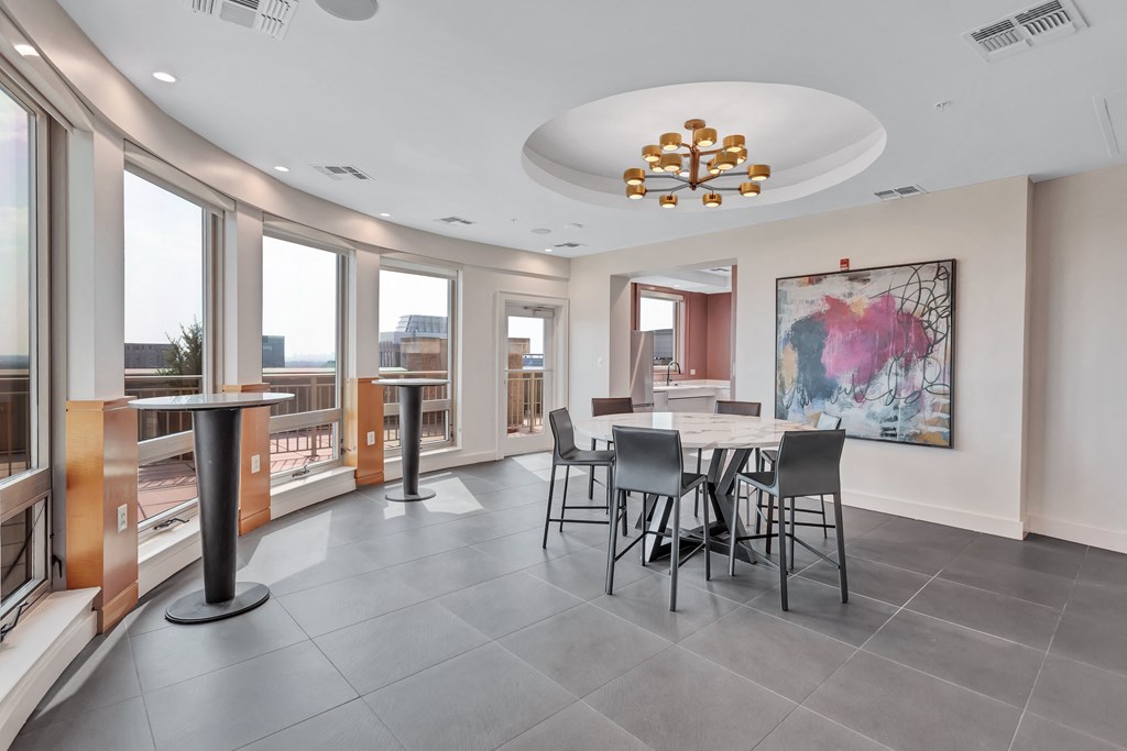 a dining room with a large table and chairs and a large window