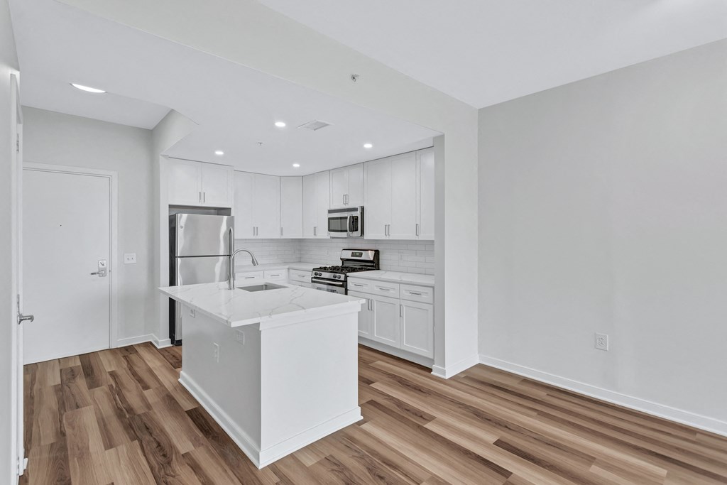 a white kitchen with a large island and white cabinets