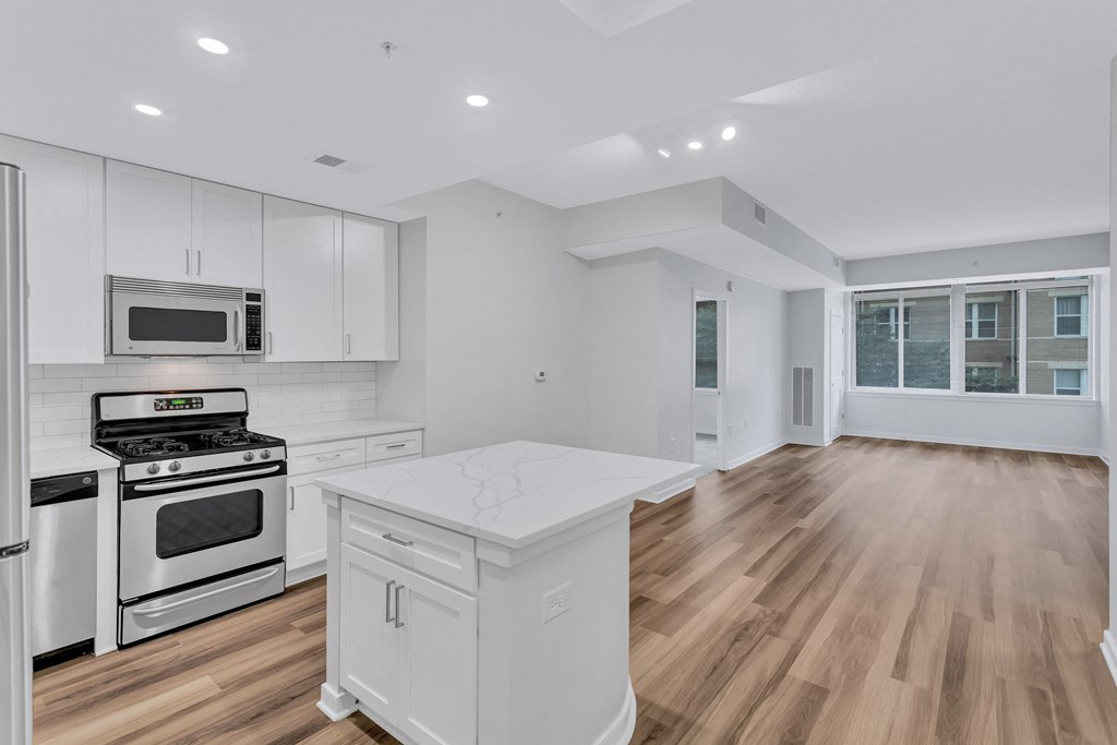a renovated kitchen with white cabinets and white counter tops
