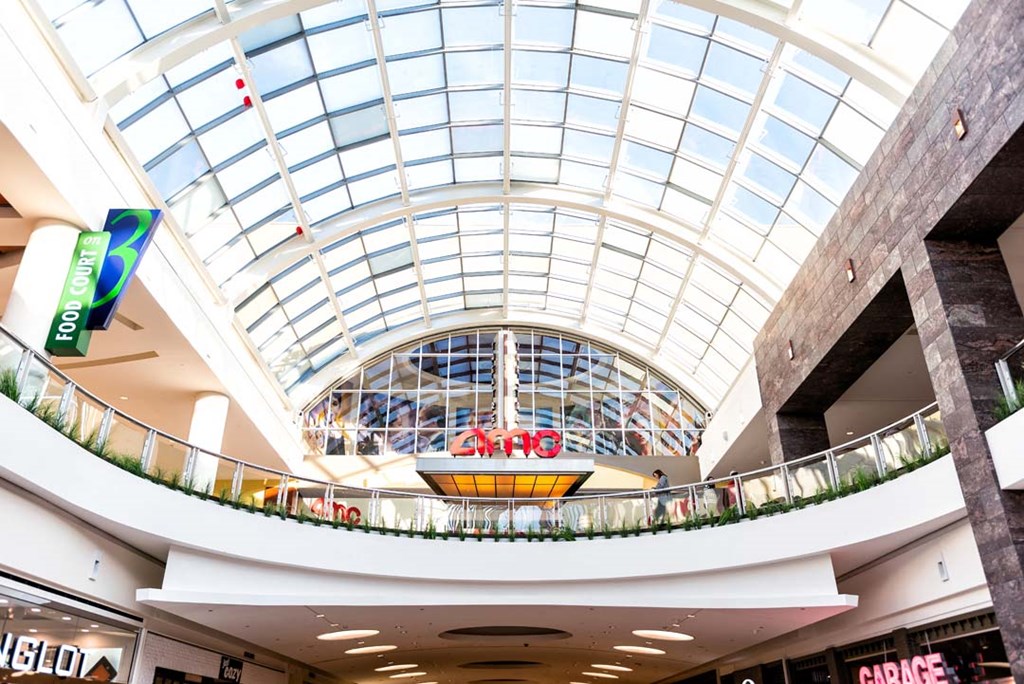 a shopping mall with a large glass ceiling and a sign