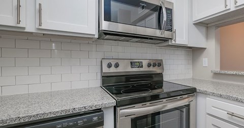 A modern kitchen with a stove top oven and microwave above it.