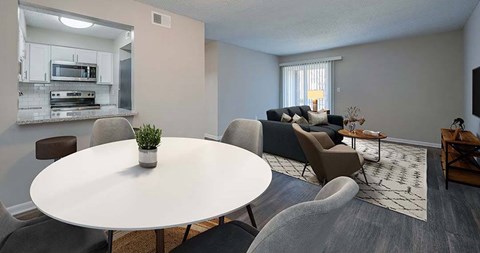 a living room and kitchen with a table and chairs