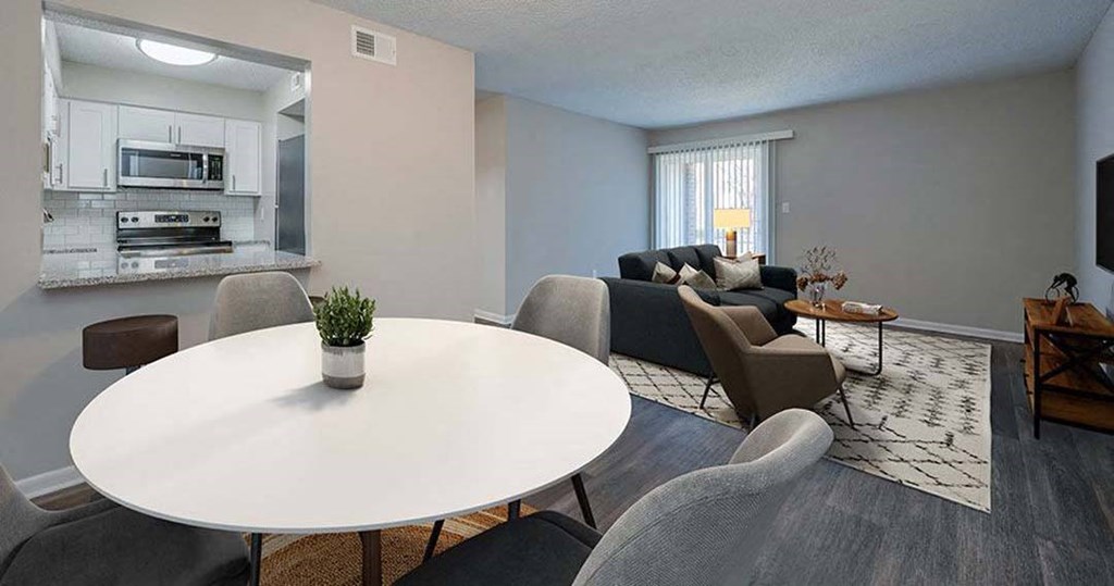 a living room and kitchen with a table and chairs