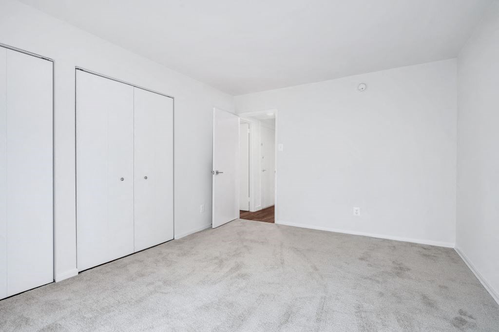 an empty bedroom with white walls and white doors