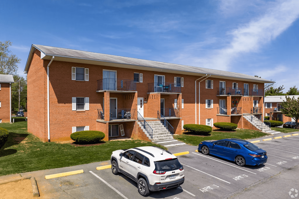 an apartment building with cars parked in front of it