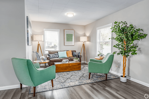 a living room with two green chairs and a couch