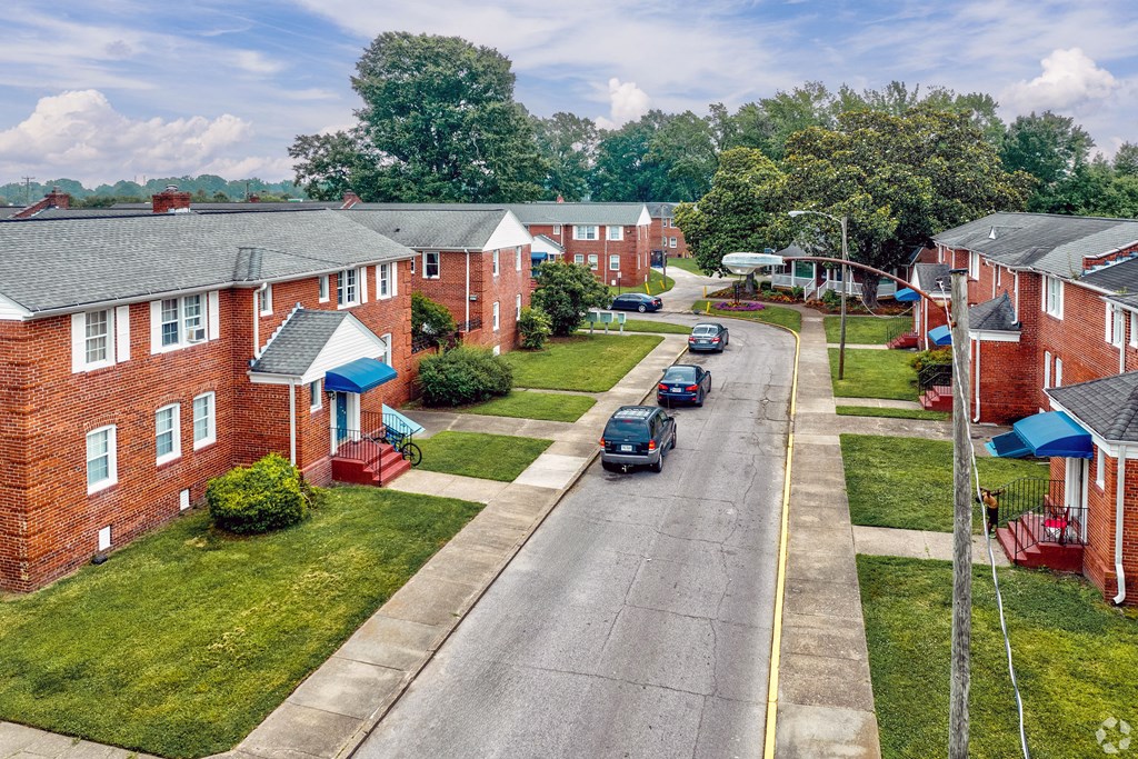 an aerial view of a neighborhood with cars driving down a street