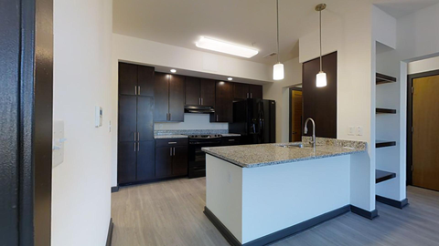 a kitchen with a large island and dark wood cabinets