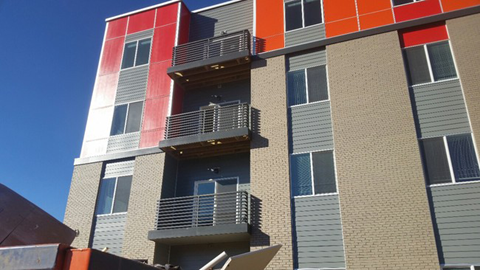 a tall building with balconies and a blue sky