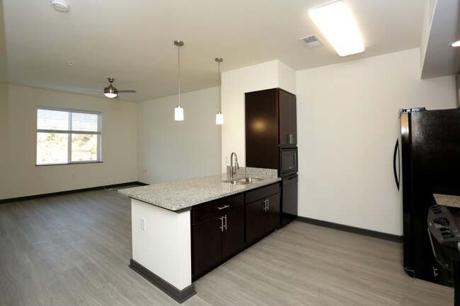 an empty kitchen with a refrigerator and a sink