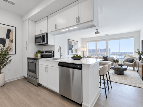 A modern kitchen with white cabinets and stainless steel appliances.
