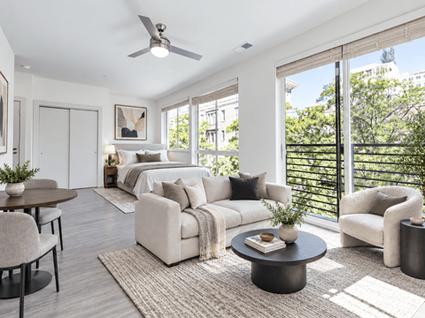 A well-lit, modern living room with a large window and a sliding glass door.