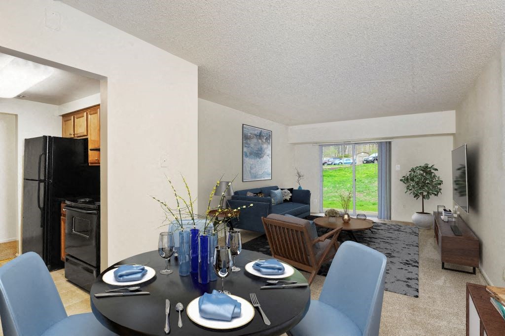 a dining room table with blue chairs in front of a living room