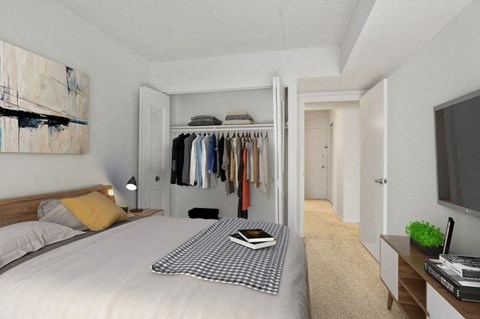 a bedroom with a bed and a closet with clothes on it