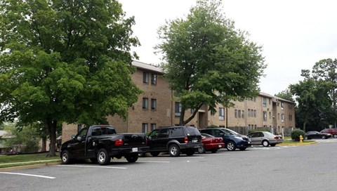 a parking lot with cars parked in front of an apartment building
