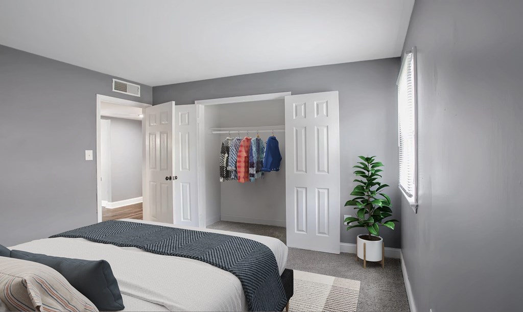 A bedroom with a bed, a wardrobe, and a plant.