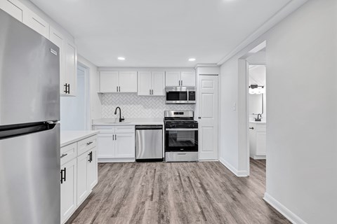 A kitchen with a refrigerator on the left and a dishwasher on the right.