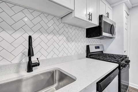 A modern kitchen with a black oven and a black microwave above it.