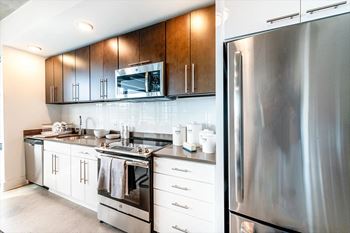 a kitchen with white cabinets and stainless steel appliances