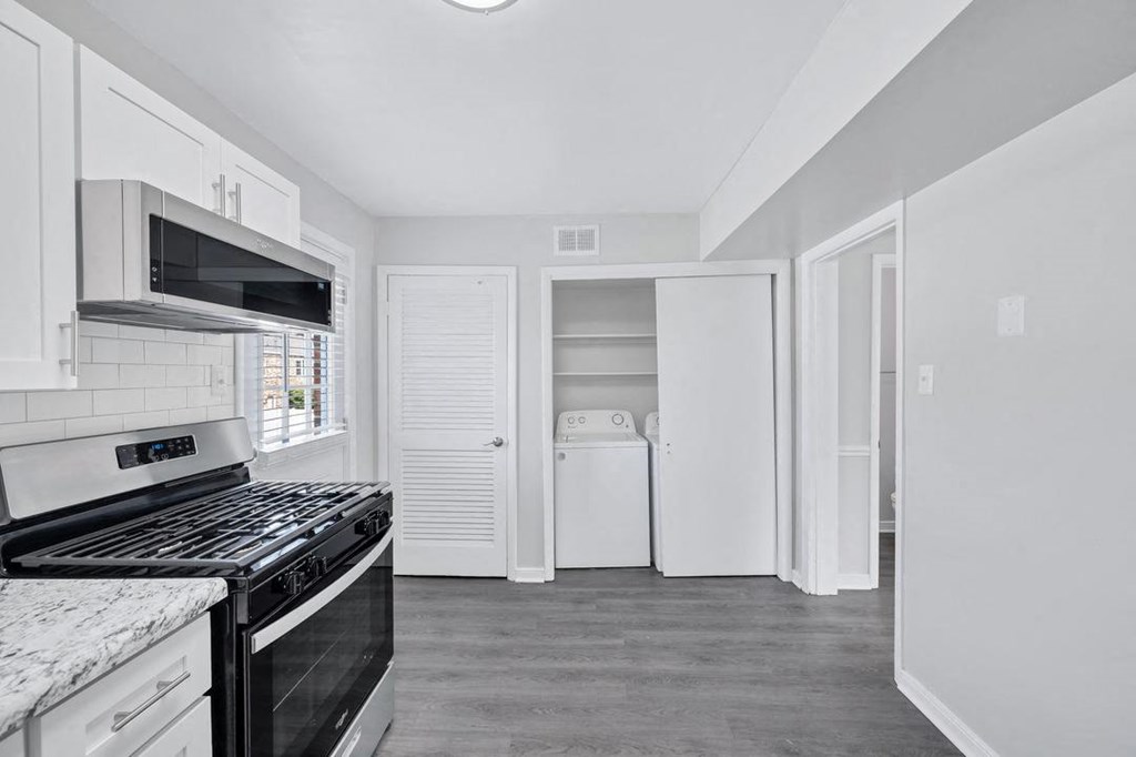 a kitchen with white cabinets and a black stove top oven