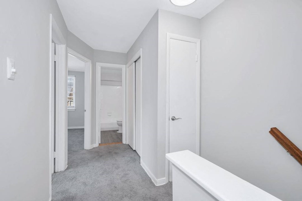 a bedroom with grey carpet and white walls