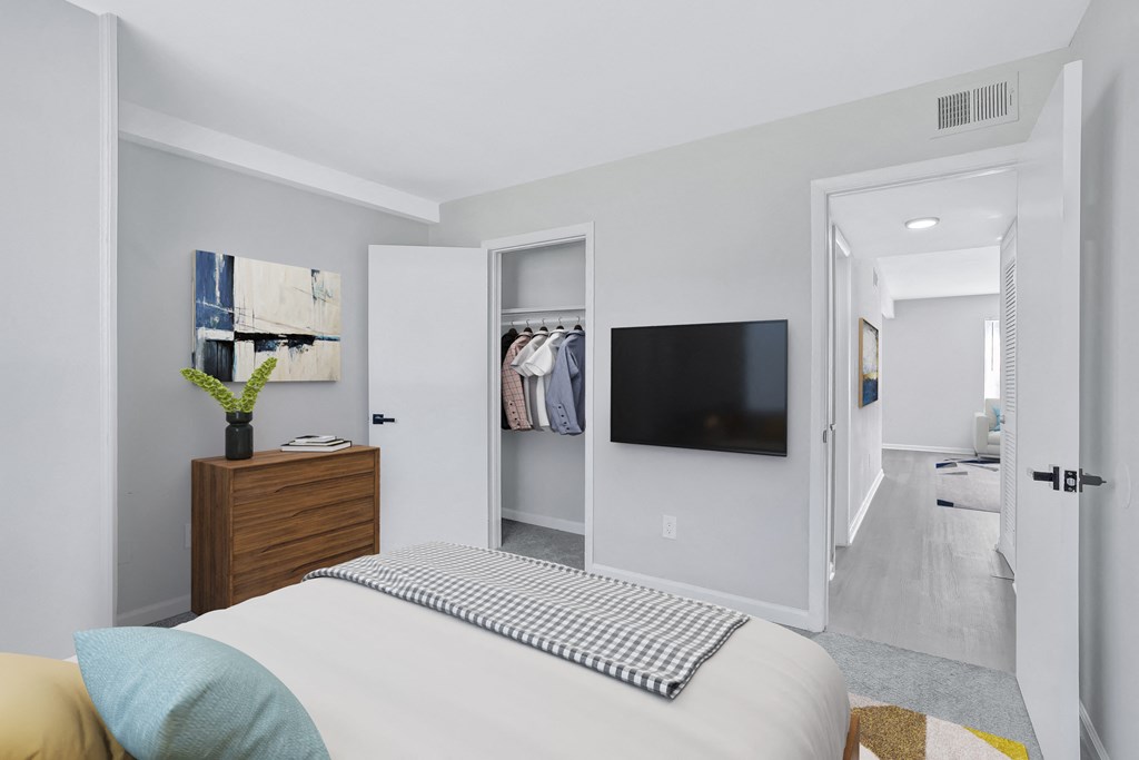 a bedroom with a large bed and a tv in a closet